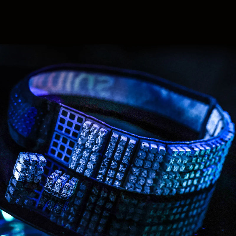 Pulseira esportiva preta com detalhes geométricos brilhantes sob luz azul, destaque Orca Sports